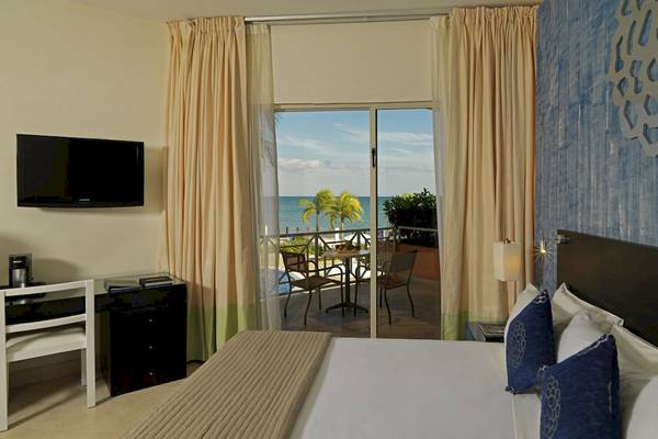 Hotelzimmer im Ocean Maya Royale mit Blick auf die Terrasse und das Meer.