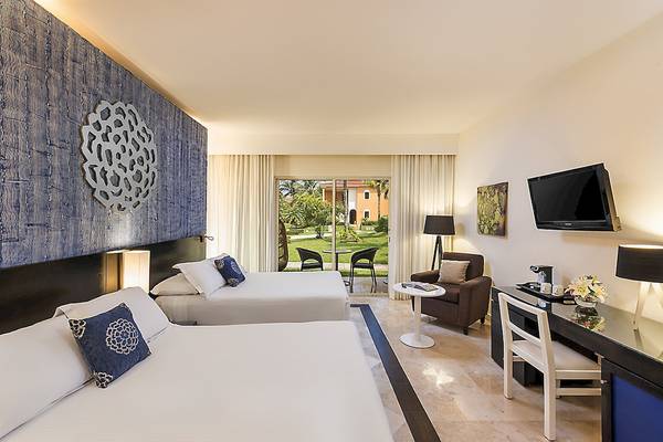 Doppelzimmer im Ocean Maya Royale Hotel mit zwei Betten, Blick auf den Garten und moderner Einrichtung.