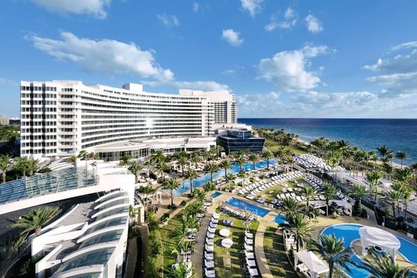 Außenansicht des Fontainebleau Miami Beach Hotels mit Swimmingpools und Palmen