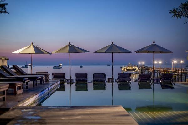 Abendlicher Blick auf den Pool des Punnpreeda Beach Resort mit Sonnenschirmen und Liegen am Wasser