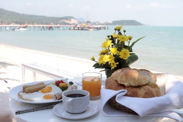 Frühstück am Strand im Punnpreeda Beach Resort mit Blick auf das Meer und eine Insel.