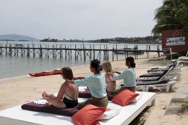 Yoga-Sitzung am Strand des Punnpreeda Beach Resort mit Frauen, die auf Kissen sitzen und sich entspannen.