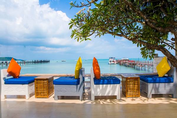 Außenbereich des Punnpreeda Beach Resorts mit Blick auf den Ozean und einer Lounge mit Kissen.