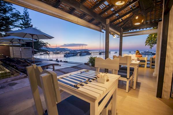 Das Punnpreeda Beach Resort zeigt ein Restaurant mit Blick auf das Meer und Boote bei Sonnenuntergang.