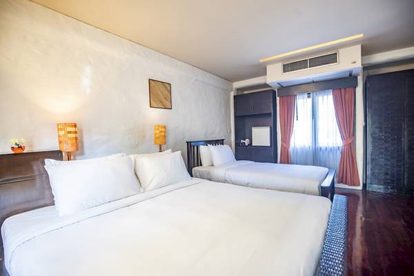 Zwei Betten im Zimmer des Punnpreeda Beach Resort, beide mit weißen Laken und Kissen.