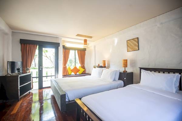 Zwei Betten im Schlafzimmer des Punnpreeda Beach Resort mit weißen Laken und Kissen.