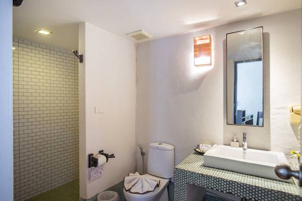 Badezimmer im Punnpreeda Beach Resort mit Dusche, Toilette und Waschbecken.
