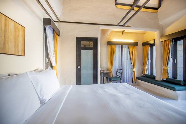 Punnpreeda Beach Resort Zimmer mit Bett, Fenstern und Dekor.