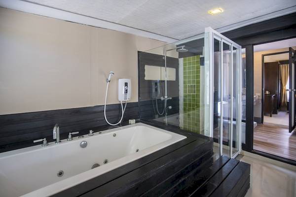 Badezimmer im Punnpreeda Beach Resort mit Badewanne und Glasdusche.
