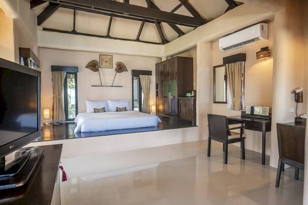 Hotelzimmer des Punnpreeda Beach Resort mit Bett, Fernseher und Schreibtisch.