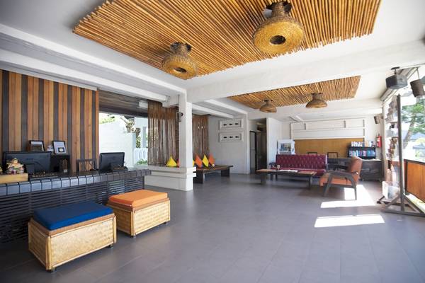 Lobbybereich des Punnpreeda Beach Resorts mit Holzmöbeln und bunten Kissen.