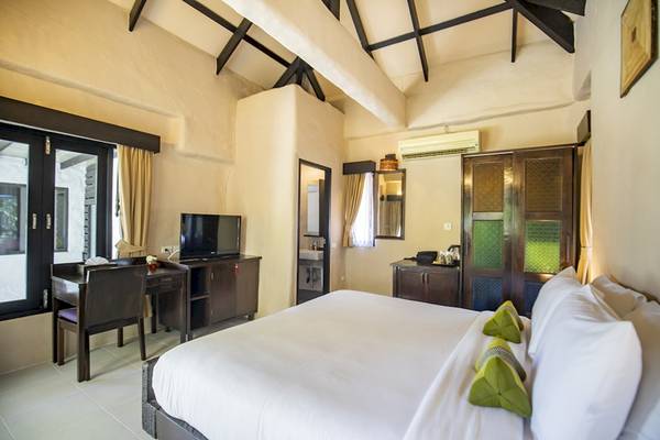 Hotelzimmer des Punnpreeda Beach Resort mit Bett, Schreibtisch und Fernseher.