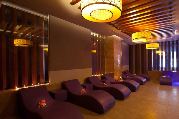 Loungebereich im Side Aluna Hotel mit violetten Liegestühlen und dekorativen Lichtern.