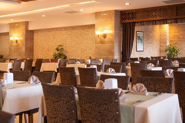 Innenansicht des Restaurants des Side Aluna Hotels mit gedeckten Tischen und dekorativen Wandelementen.
