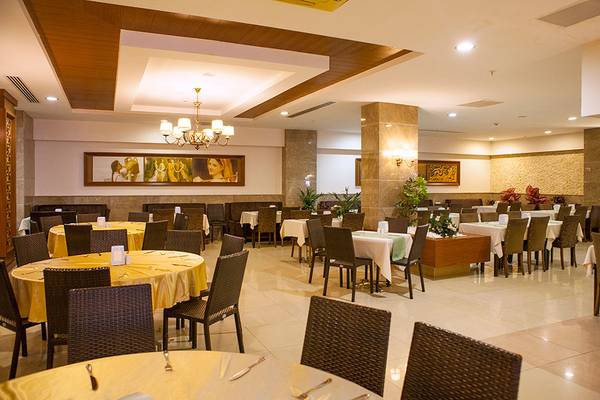 Innenansicht des Restaurants im Side Aluna Hotel mit runden Tischen und Stühlen.