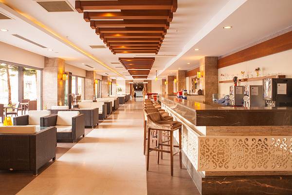 Loungebereich im Side Aluna Hotel mit gepolsterten Sesseln und einer Bar.