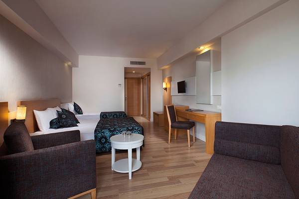 Schlafzimmer im Side Aluna Hotel mit zwei Betten, Schreibtisch und Couch.
