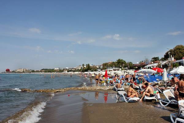 Strand des Horus Paradise Luxury Resort mit vielen Gästen und Sonnenschirmen