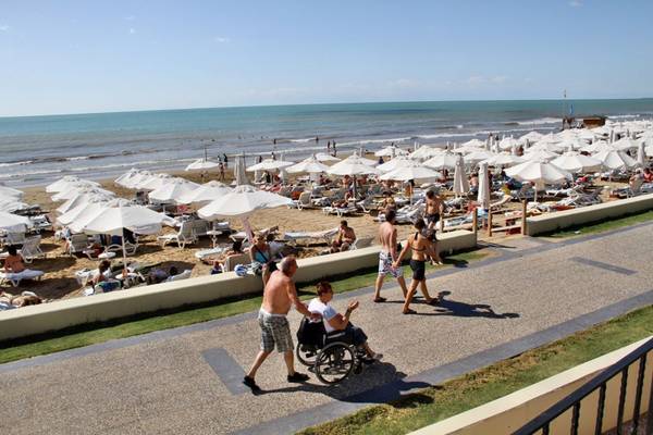 Ein Strand mit vielen Sonnenschirmen, Liegen und Besuchern, ein Hotelname Horus Paradise Luxury Resort.