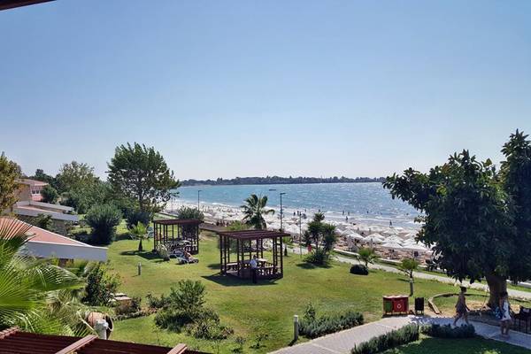 Aussicht auf den Strand vom Horus Paradise Luxury Resort mit Gebäuden, Bäumen und Menschen.