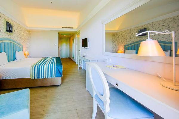 Luxuriöses Hotelzimmer im Horus Paradise Luxury Resort mit Bett, Schreibtisch und Fernseher.