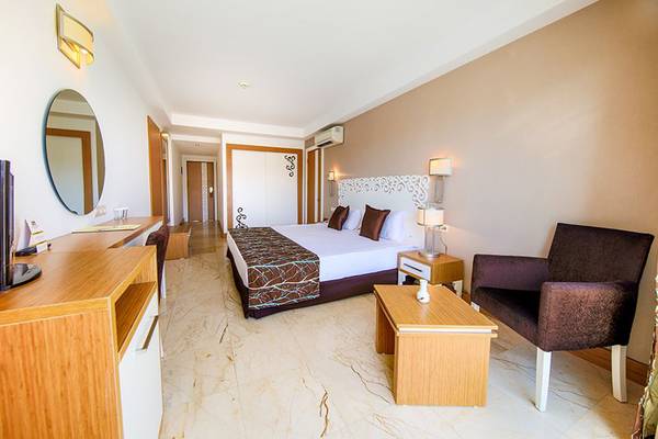 Hotelzimmer im Horus Paradise Luxury Resort mit Bett, Möbeln und Fernseher.