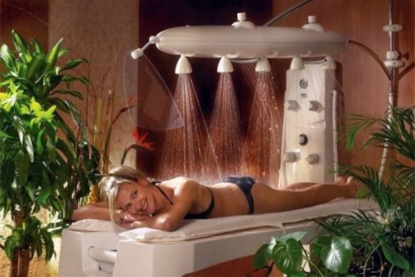 Eine Frau genießt eine Entspannungsbehandlung in einer Sauna mit tropfender Dusche im Horus Paradise Luxury Resort.