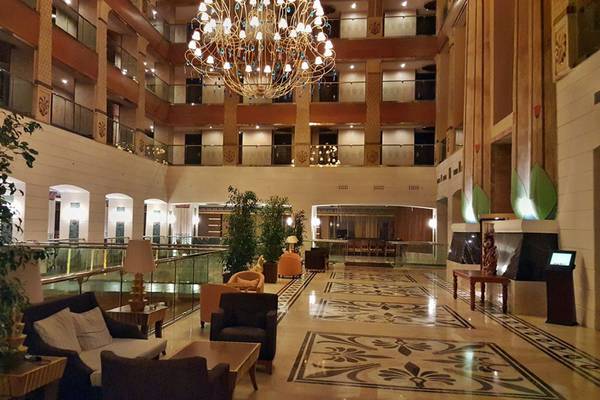 Eingangsbereich des Horus Paradise Luxury Resort mit einer großen Kristallkronleuchter, Sofas und Pflanzen.