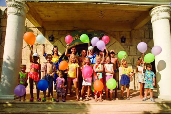 Gruppe von Kindern und Erwachsenen mit bunten Luftballons vor dem Horus Paradise Luxury Resort