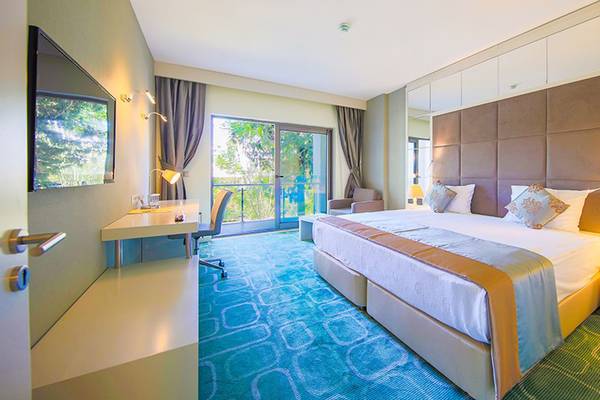 Hotelzimmer im Horus Paradise Luxury Resort mit Bett, Schreibtisch und Balkon