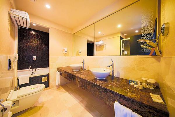 Badezimmer im Horus Paradise Luxury Resort mit zwei Waschbecken, einem Badezimmerspiegel und einer Badewanne.