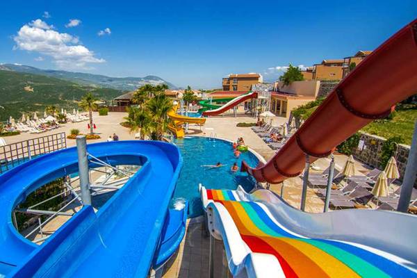 Wasserrutschen im Wyndham Residences Kusadasi Golf & Spa Hotel mit blauem Himmel im Hintergrund.