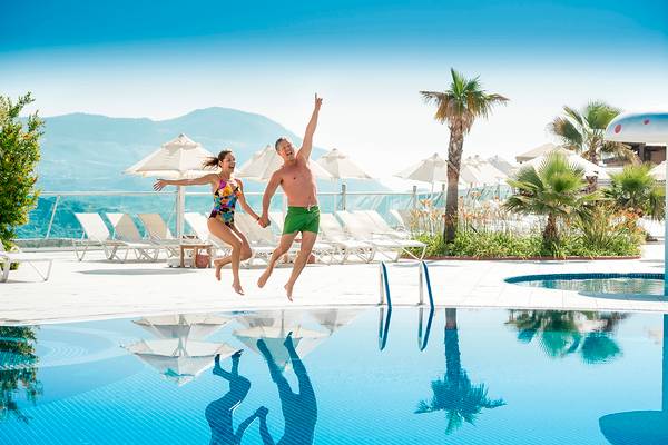 Paar springt im Pool des Wyndham Residences Kusadasi Golf & Spa