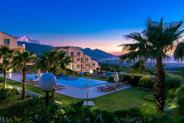 Außenbereich des Wyndham Residences Kusadasi Golf & Spa mit Pool und Liegestühlen