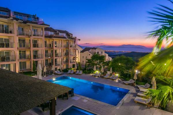 Aussenbereich des Wyndham Residences Kusadasi Golf & Spa mit Pool und Liegewiese.