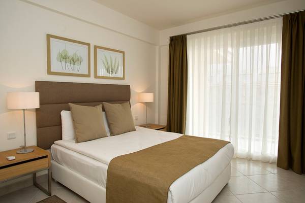 Schlafzimmer mit Doppelbett, Lampen und Fenstern im Wyndham Residences Kusadasi Golf & Spa Hotel