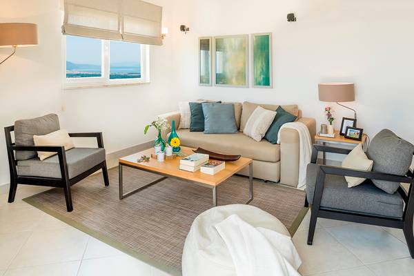 Wohnzimmer im Wyndham Residences Kusadasi Golf & Spa Hotel mit Sofa, Tischen und Fensterblick.
