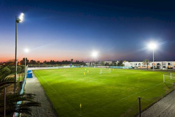 Sportplatz des El Mouradi Club Kantaoui bei Nacht, mit Beleuchtung und Gebäude im Hintergrund.