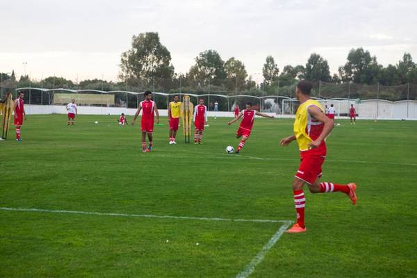 Spieler des El Mouradi Club Kantaoui trainieren auf einem Fußballfeld.