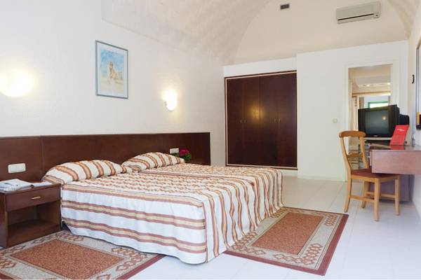 Hotelzimmer im El Mouradi Club Kantaoui mit Doppelbett, Nachttischen, Schrank und Fernseher.