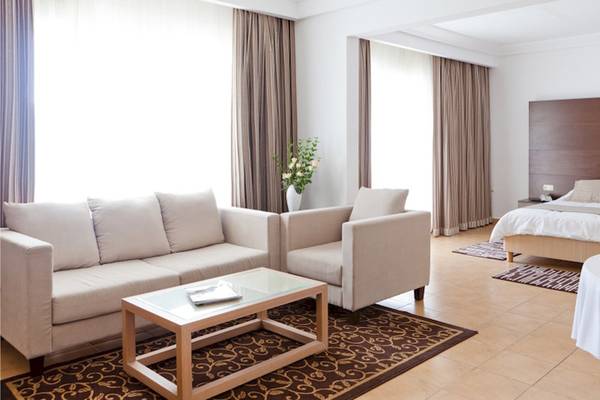 Schlafzimmer im El Mouradi Club Kantaoui Hotel mit einem Bett, Sofas und einem Tisch.