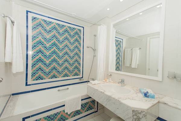 Badezimmer des El Mouradi Palace Hotels mit Badewanne und blauen Kacheln
