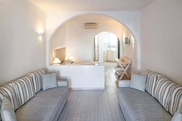 Wohnbereich des Aegean Plaza Hotels mit zwei Sofas, Tisch und Fernseher.