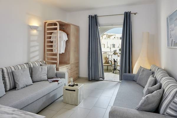 Wohnzimmer im Aegean Plaza Hotel mit zwei Sofas, einem Tisch, einem Kleiderschrank und einem Balkon.
