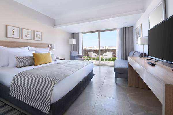 Innenansicht eines eleganten Hotelzimmers im Iberotel Costa Mares mit großem Bett, Fernseher und Balkon