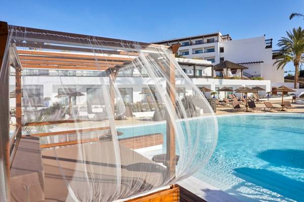 Pool-Lounge im Secrets Lanzarote Resort & Spa mit Blick auf das Hotel und Sonnenliegen.