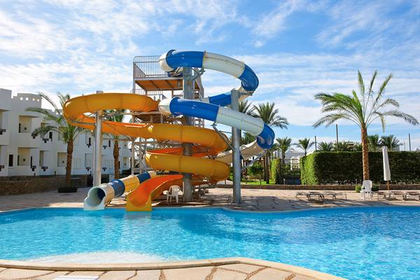 Wasserrutsche im Sharm Resort mit mehreren Farbbahnen vor einem Gebäude.