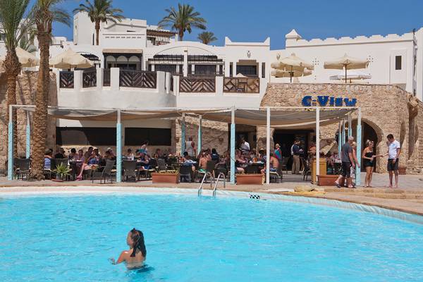 Ein Hotelpool mit Gästen, die um den Pool herum sitzen und trinken, Sharm Resort C-View