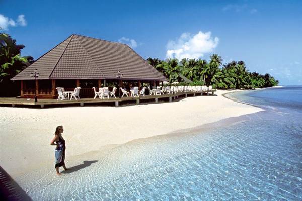 Frau am Strand vor dem Holiday Island Resort & Spa