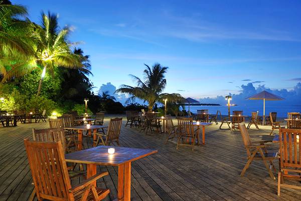 Abendessen auf der Terrasse des Holiday Island Resort & Spa mit Tischen und Stühlen im Freien.
